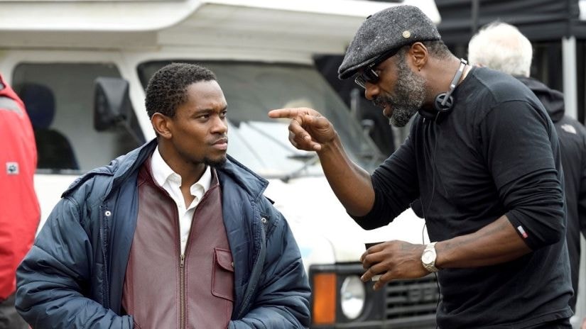 Idris Elba (R) directing Aml Ameen in Yardie. Twitter/@AmlAmeen