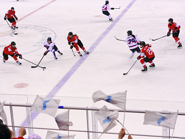 North Korea's cheerleaders wave the Unified Korea flag and cheer during the women's preliminary round ice hockey match between Switzerland and the Unified Korean team during the Pyeongchang 2018 Winter Olympic Games at the Kwandong Hockey Centre in Gangneung on February 10, 2018. / AFP PHOTO / Jung Yeon-je