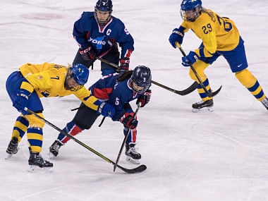 Unified Korea's Caroline Nancy Park (front R) clashes with Sweden's Johanna Olofsson (L), as Unified Korea's Park Jongah (back L) and Sweden's Olivia Carlsson watch, during the women's preliminary round ice hockey match between Sweden and Unified Korea during the Pyeongchang 2018 Winter Olympic Games at the Kwandong Hockey Centre in Gangneung on February 12, 2018. / AFP PHOTO / Ed JONES