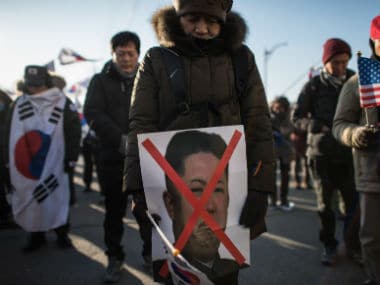 An anti-North Korean protester holds a picture of North Korean leader Kim Jong-Un. AFP