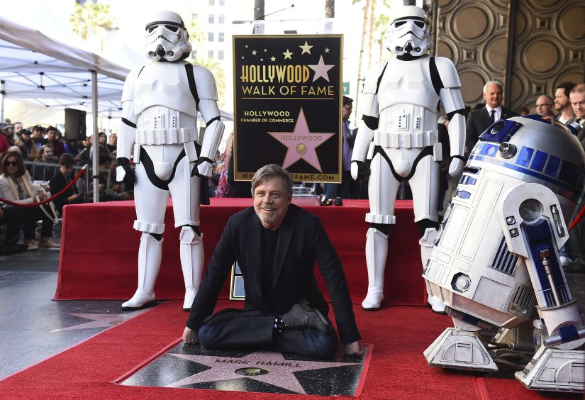 Mark Hamill, who plays Luke Skywalker in the "Star Wars" films, poses at a ceremony honoring him with a star on the Hollywood Walk of Fame as droid character R2-D2, and men dressed as Stormtroopers appear nearby on Thursday, March 8, 2018 in Los Angeles. (Photo by Jordan Strauss/Invision/AP)