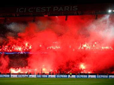 FILE - A Tuesday, March 6, 2018 file photo of PSG's fans holding flares during the round of 16, 2nd leg Champions League soccer match between Paris Saint-Germain and Real Madrid at the Parc des Princes Stadium in Paris. Paris Saint-Germain must close part of its stadium at its next Champions League home game as punishment for fans lighting flares and fireworks.UEFA says the north end of Parc des Princes will close due to incidents at PSG’s 2-1 loss against Real Madrid this month, eliminating the French club from the Round of 16. (AP Photo/Francois Mori, File)