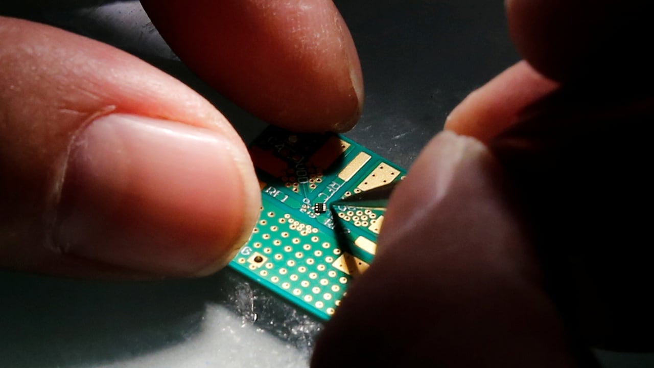 A researcher plants a semiconductor on an interface board during a research work to design and develop a semiconductor product at Tsinghua Unigroup research centre in Beijing, China, February 29, 2016. REUTERS/Kim Kyung-Hoon - D1AETETVAHAA
