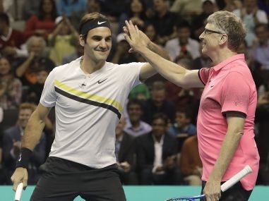 Roger Federer celebrates with partner Bill Gates during their exhibition match against Jack Sock and Savannah Guthrie. AP