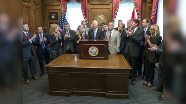 Florida governor Rick Scott signs gun restrictions three weeks after Parkland high school attack; NRA files lawsuit to block law