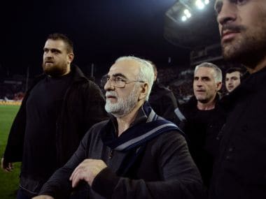 File photo of PAOK owner, businessman Ivan Savvidis, center, walking on the pitch escorted by his bodyguards. AP