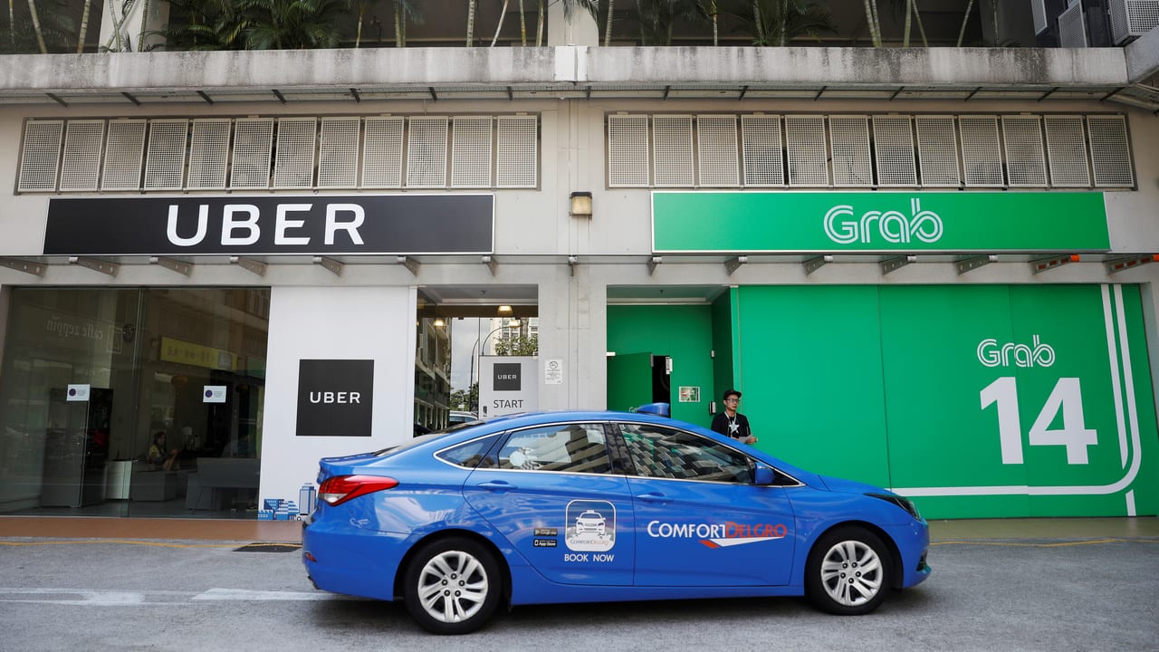 A ComfortDelgro taxi passes Uber and Grab offices in Singapore March 26, 2018. REUTERS/Edgar Su TPX IMAGES OF THE DAY - RC189FFFDF00