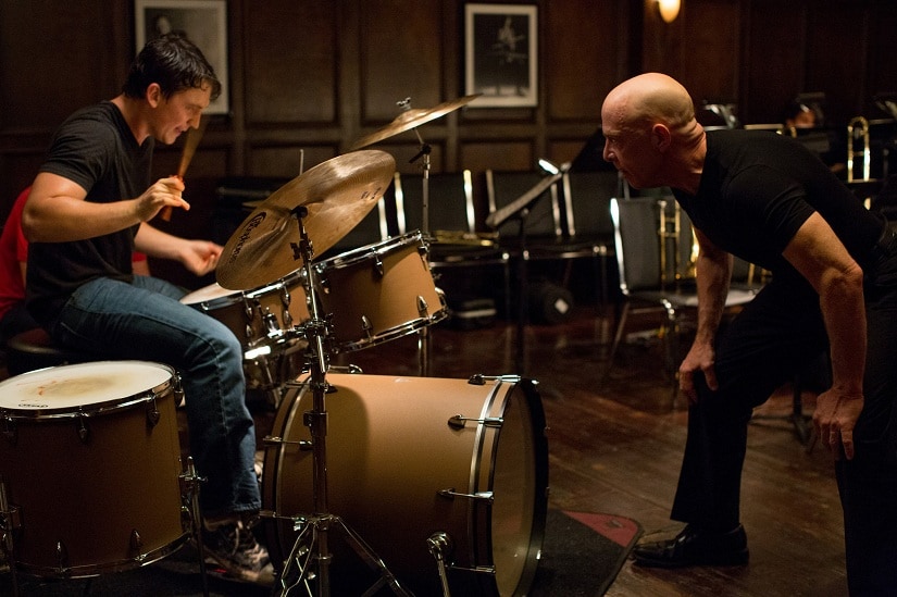 Terence Fletcher (JK Simmons) pushes an aspiring jazz drummer, Andrew Neyman (Miles Teller), past his physical and mental limits in Whiplash.