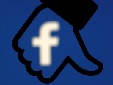 A 3D-printed Facebook dislike button is seen in front the Facebook logo. Image: Reuters