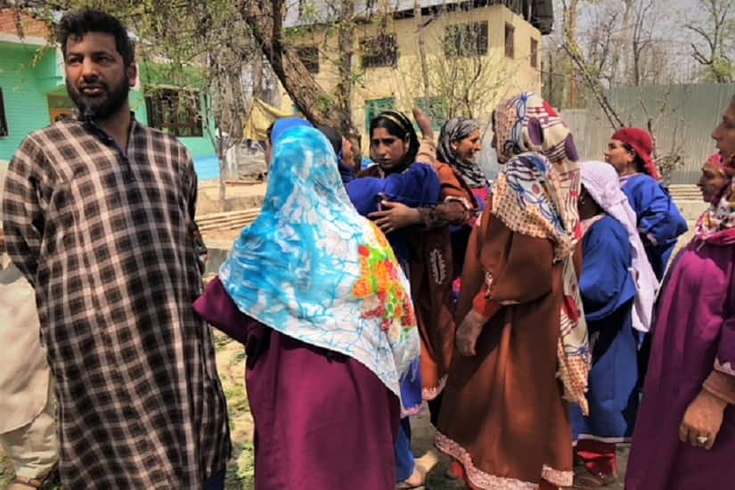 Mubeena Lone and her brother-in-law Neeyaz Ahmad Lone, watch people throng the site of the gun battle. Firstpost/Sameer Yasir