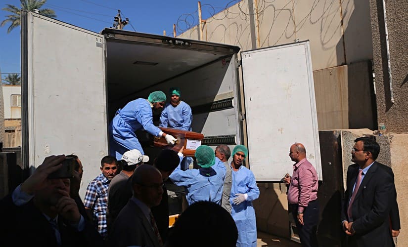 Pradeep Singh Rajpurohit, right, India’s Ambassador to Iraq, watches while a casket holding one of 38 Indians abducted and killed by the Islamic State is loaded on a truck. AP