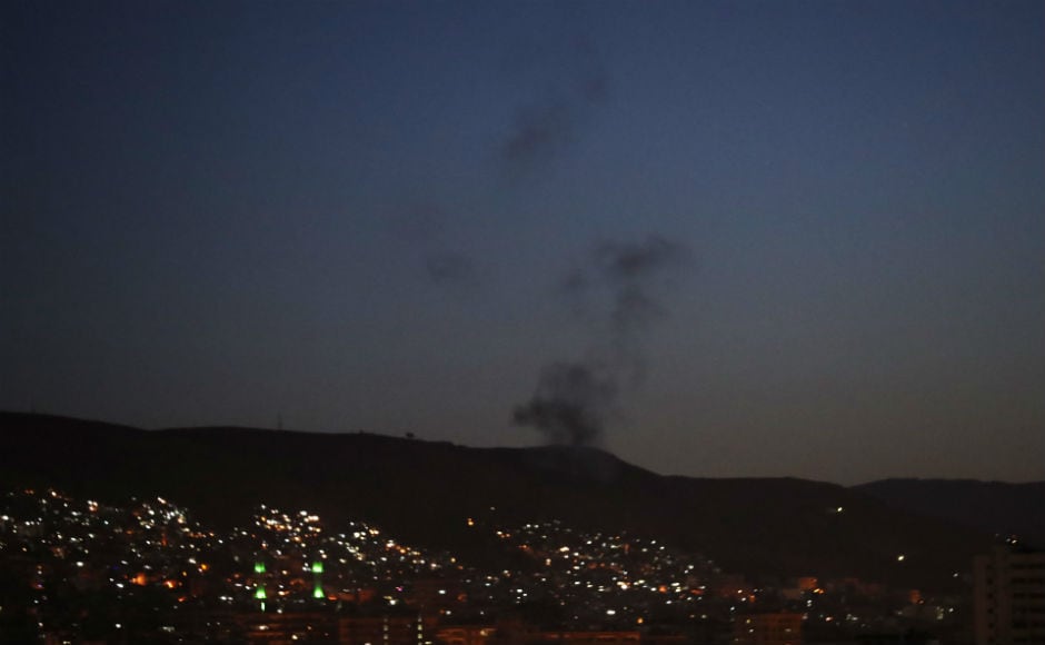 Smoke rising from east Damascus due to air strike. Syrian media reported that air defenses hit 13 rockets south of Damascus. After the attack ceased and the early morning skies went dark once more, vehicles with loudspeakers roamed the streets of Damascus blaring nationalist songs. AP Smoke rising from east Damascus due to air strike. Syrian media reported that air defenses hit 13 rockets south of Damascus. After the attack ceased and the early morning skies went dark once more, vehicles with loudspeakers roamed the streets of Damascus blaring nationalist songs. AP
