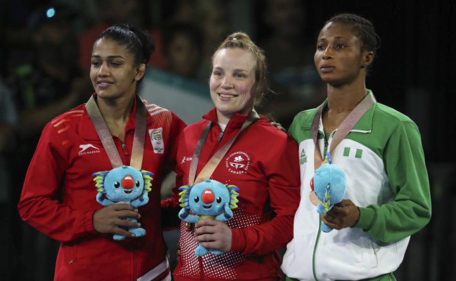 Canada's Gold medalist in women's FS 53Kg wrestling Dina Weicker, center, stands with India's Silver medalist Babita Kumari and Nigeria's Bronze medalist Bose Samuel during a medal ceremony. AP Canada's Gold medalist in women's FS 53Kg wrestling Dina Weicker, center, stands with India's Silver medalist Babita Kumari and Nigeria's Bronze medalist Bose Samuel during a medal ceremony. AP