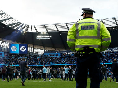 Manchester City fans invade the pitch after the game as police look on. Reuters