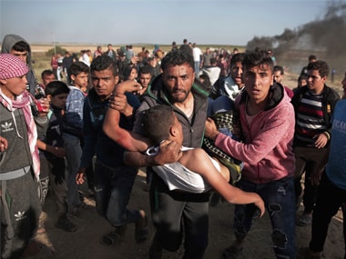 Palestinian protesters carry a wounded man who was shot by Israeli troops during a protest near the Gaza Strip border with Israel on Saturday. AP