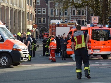 Rescue workers stand outside the area after the car crashed into the crowd. AP