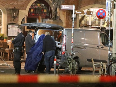 A body is loaded into a vehicle in front of a restaurant in Muenster, Germany. AP
