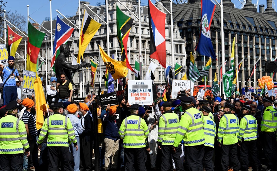 Police officers stand in front of demonstrators protesting against Modi in Parliament Square in London. Reuters Police officers stand in front of demonstrators protesting against Modi in Parliament Square in London. Reuters