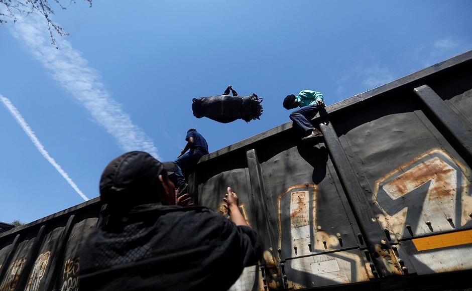 Central American migrants, moving in a caravan through Mexico, throw their blankets as they disembark from a freight train in Tlaquepaque, in Jalisco state. REUTERS Central American migrants, moving in a caravan through Mexico, throw their blankets as they disembark from a freight train in Tlaquepaque, in Jalisco state. REUTERS