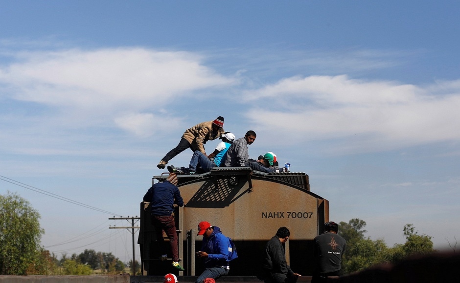 Central American migrants, moving in a caravan through Mexico, travel on a wagon of a freight train after stopping it on the rail line, in Michoacan state, Mexico. REUTERS Central American migrants, moving in a caravan through Mexico, travel on a wagon of a freight train after stopping it on the rail line, in Michoacan state, Mexico. REUTERS