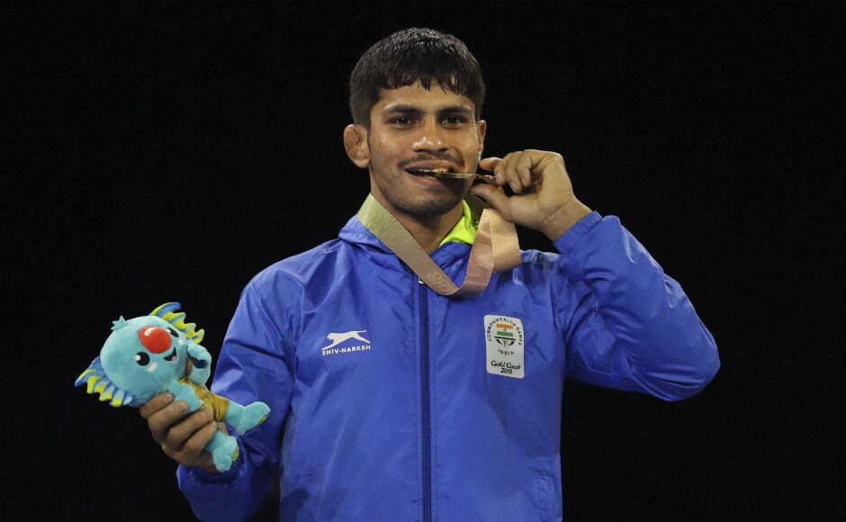 India's Gold medalist in men's FS 57Kg wrestling Rahul Aware bits his medal soon after a medal ceremony. AP India's Gold medalist in men's FS 57Kg wrestling Rahul Aware bits his medal soon after a medal ceremony. AP