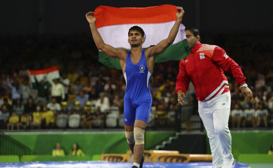 India's Rahul Aware, in blue, celebrates soon after wining against Canada's Steven Takahashi to win Gold medal in men's FS 57Kg wrestling. AP India's Rahul Aware, in blue, celebrates soon after wining against Canada's Steven Takahashi to win Gold medal in men's FS 57Kg wrestling. AP
