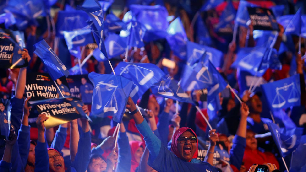 Supporters of Malaysia's ruling party National Front waves the party flags during the launch of its manifesto. Image: Reuters