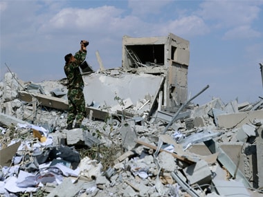 A Syrian soldier films the damage of the Syrian Scientific Research Center which was attacked by U.S., British and French military strikes. AP