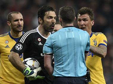 Juventus' Italian goalkeeper Gianluigi Buffon (2L) argues with the referee during the UEFA Champions League quarter-final second leg football match between Real Madrid CF and Juventus FC at the Santiago Bernabeu stadium in Madrid on April 11, 2018. / AFP PHOTO / OSCAR DEL POZO