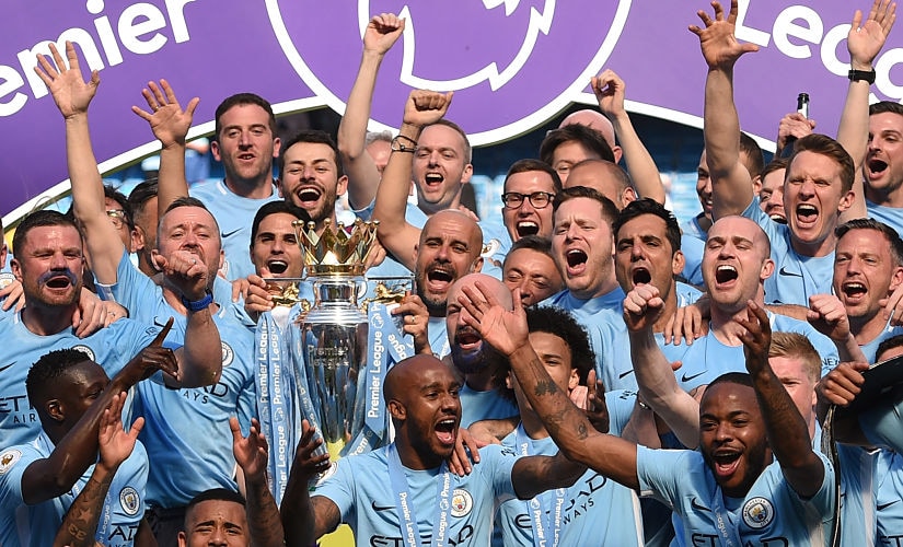Manchester City's Spanish manager Pep Guardiola (C) holds the Premier League trophy on the pitch with Manchester City players after the English Premier League football match between Manchester City and Huddersfield Town at the Etihad Stadium in Manchester, north west England, on May 6, 2018. / AFP PHOTO / Oli SCARFF / RESTRICTED TO EDITORIAL USE. No use with unauthorized audio, video, data, fixture lists, club/league logos or 'live' services. Online in-match use limited to 75 images, no video emulation. No use in betting, games or single club/league/player publications. /