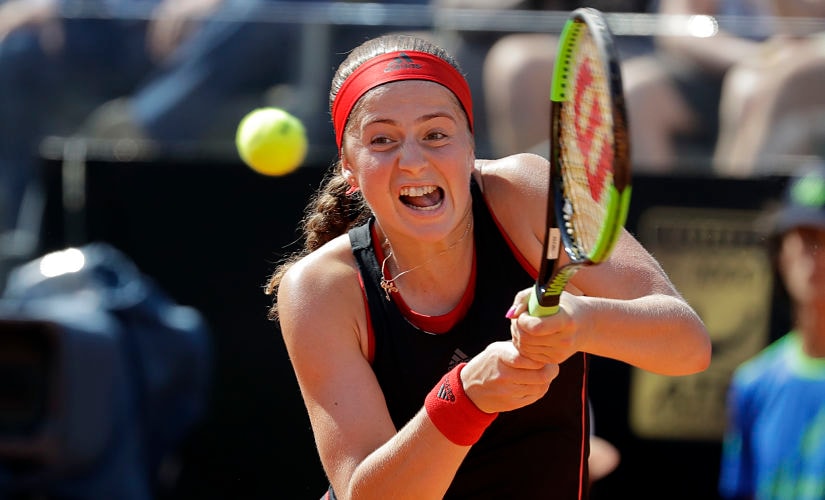 FILE - In this May 18, 2018, file photo, Latvia's Jelena Ostapenko returns the ball to Russia's Maria Sharapova at the Italian Open tennis tournament in Rome. Ostapenko will be competing in the French Open tennis tournament that begins on Sunday, May 27.(AP Photo/Andrew Medichini, File)