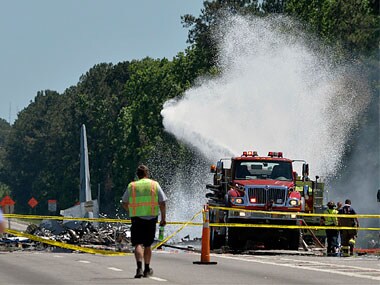 A firetruck sprays foam over the remains of an Air National Guard C-130 cargo plane from Puerto Rico that crashed in Georgia, AP