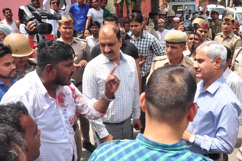 Kamal Walia, in blood stained clothes, the brother of deceased talking to government official on Wednesday. Image courtesy PC Mahesh Kumar