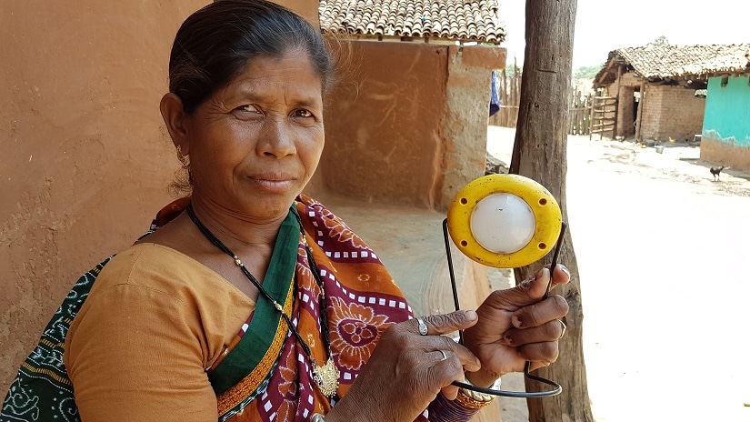 Rina Chinda of Kholibithar village in Nuapada flaunts the standalone solar light she got from the govt which is used for lighting. Image courtesy Manish Kumar.