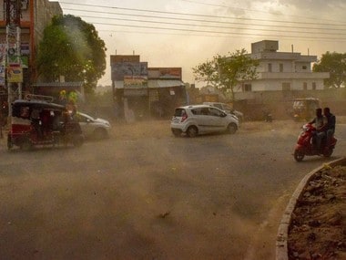 Vehicles ride past during a dust storm in Mathura on Wednesday. PTI