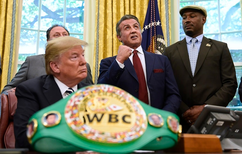FILE - In this May 24, 2018 file photo, President Donald Trump, left, and heavyweight champion boxer, Lennox Lewis, right, watch as Sylvester Stallone gestures in the Oval Office of the White House in Washington, where Trump granted a posthumous pardon to Jack Johnson, boxing's first black heavyweight champion. Stallone has announced plans for a biopic on the first African American heavyweight champion. (AP Photo/Susan Walsh, File)