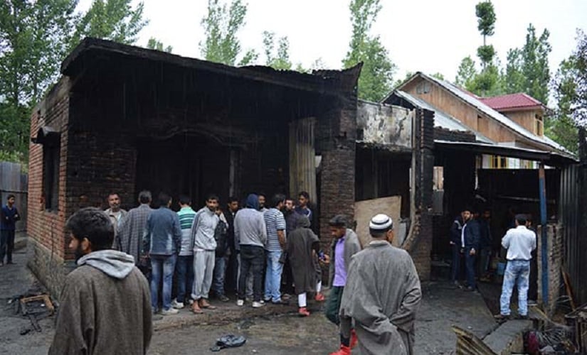 People looking at the house destroyed during an encounter in south Kashmir’s Pulwama district