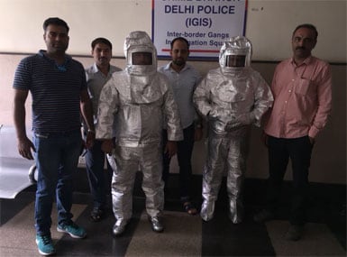 The duo were paraded by the Delhi Police in the space suits they used to scam a businessman. Twitter @DelhiPolice