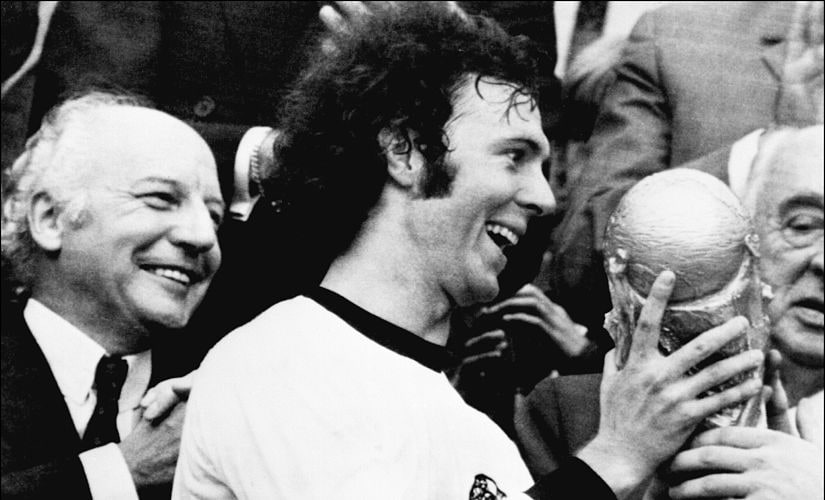 Germany's soccer star and team captain Franz Beckenbauer receives the World Soccer Cup won by his team after a 2-1 victory over Holland 07 July 1974 at Munich's Olympic stadium as West Germany president Walter Scheel applauds. Franz Beckenbauer le