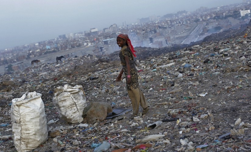 A ragpicker smiles as she collects recyclables at a dump yard in New Delhi. Reuters