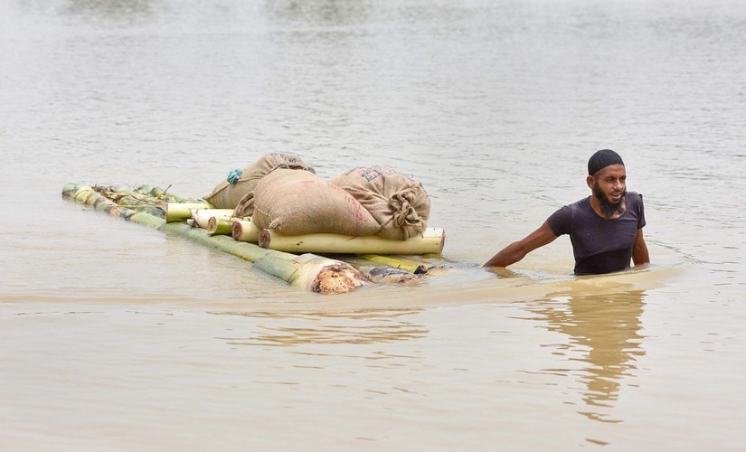 A villager transports his goods on a makeshift raft to cross across flood water, in Hojai, Assam, on Sunday. PTI