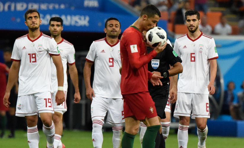 Portugal's Cristiano Ronaldo kisses the ball before taking a penalty against Iran. AFP