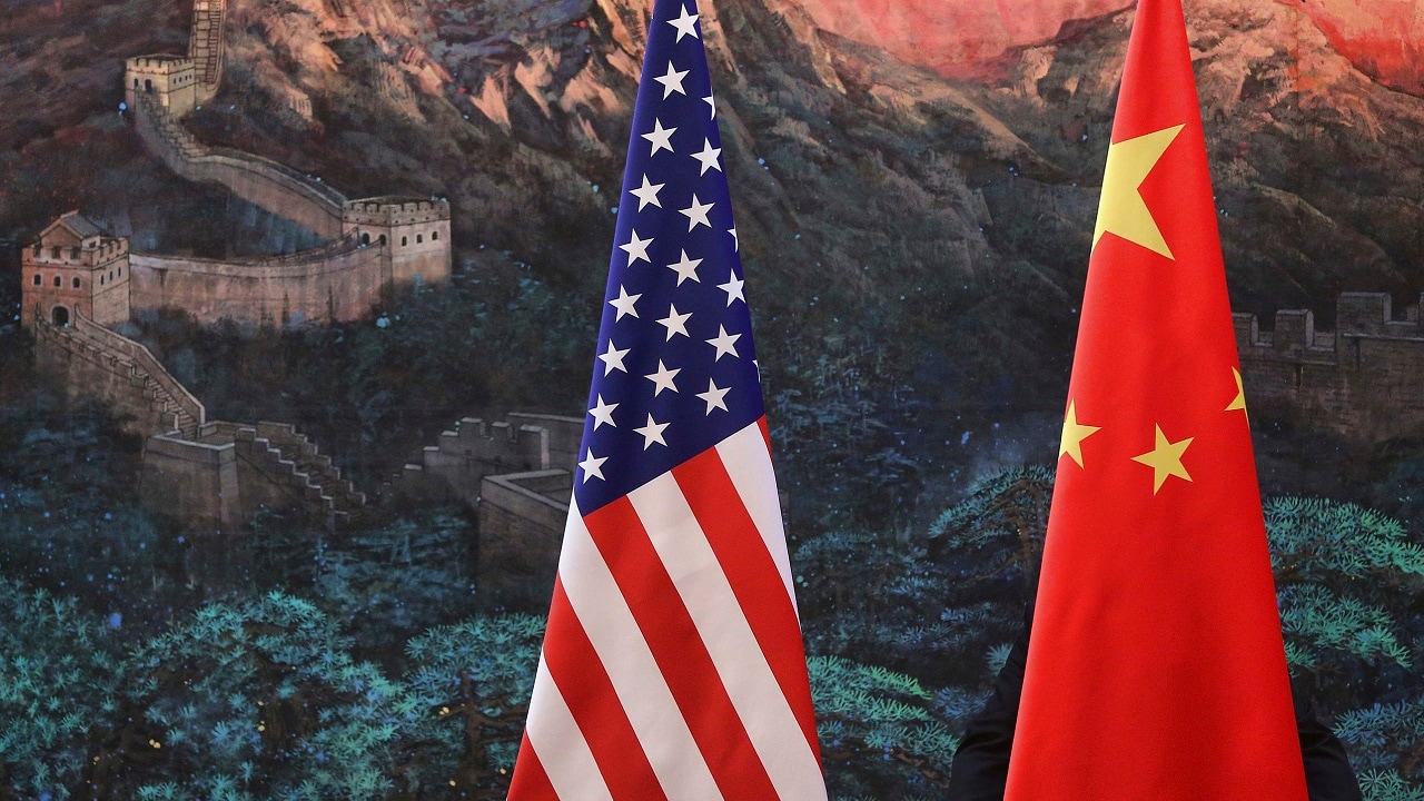 A Chinese man adjusts a China flag before a news conference attended by Chinese Foreign Minister Yang Jiechi and U.S. Secretary of State Hillary Clinton at the Great Hall of the People in Beijing September 5, 2012. China and the United States were divided on Wednesday over how to end the bloodshed in Syria and defuse tension in the South China Sea and other global troublespots, but stressed hope for steady ties as they navigate political transitions at home. REUTERS/Feng Li/Pool (CHINA - Tags: POLITICS) - GM1E89517EV01