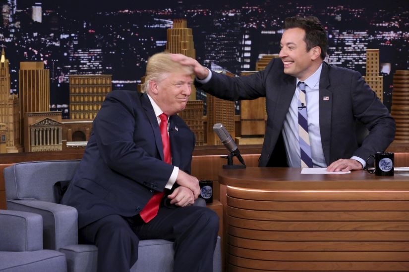 FILE - In this Sept. 15, 2016 image originally released by NBC, Republican presidential candidate Donald Trump appears with host Jimmy Fallon during a taping of "The Tonight Show Starring Jimmy Fallon," in New York. Fallon is opening up about the personal anguish he felt following the backlash to his now-infamous hair mussing appearance with Donald Trump. Trump opponents criticized Fallon for a cringeworthy interview only weeks before the election where Fallon playfully stroked Trump’s hair. (Andrew Lipovsky/NBC via AP, File)