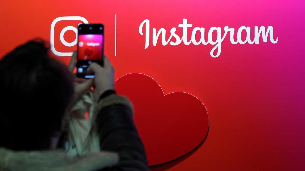 A visitor takes a picture of the Instagram application logo. Image: Reuters