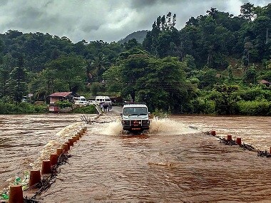 A vehicle passes through a bridge with overflowing water near Chikmagalur in Karnataka. PTI