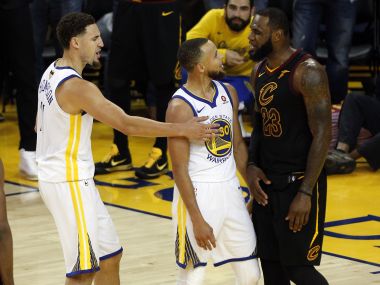 Cleveland Cavaliers' LeBron James (right) pushes Golden State Warriors' Stephen Curry (centre) as Klay Thompson intervenes. Reuters