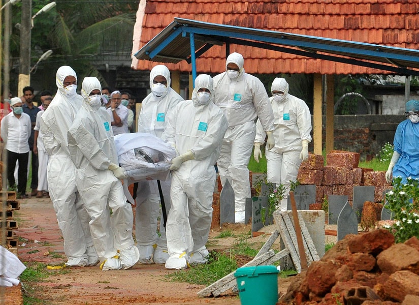 Doctors and relatives wearing protective gear carry the body of a victim, who lost his battle against the brain-damaging Nipah virus, during his funeral at a burial ground in Kozhikode, in the southern Indian state of Kerala on 24 May. Reuters
