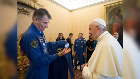 ISS Astronauts give Pope Francis his own personalised space suit which included a blue jumpsuit and a white cape