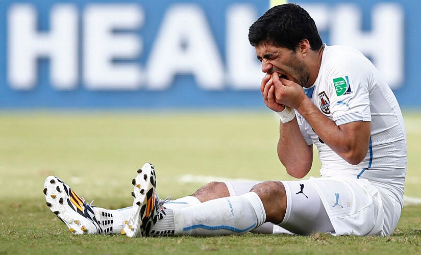 Football - Italy v Uruguay - FIFA World Cup Brazil 2014 - Group D - Estadio das Dunas, Natal, Brazil - 24/6/14 Uruguay's Luis Suarez holds his teeth after appearing to bite Italy's Giorgio Chiellini (not pictured) Mandatory Credit: Action Images / Andrew Boyers Livepic EDITORIAL USE ONLY. - MT1ACI12422159